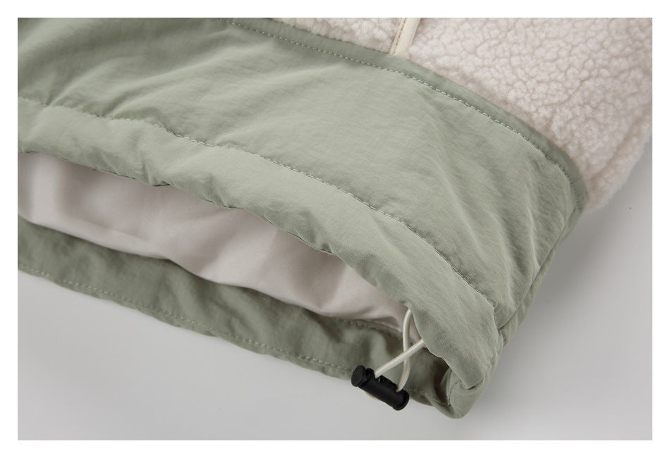 Close-up of the sage-green jacket hem with cream lining and an adjustable drawcord toggle.