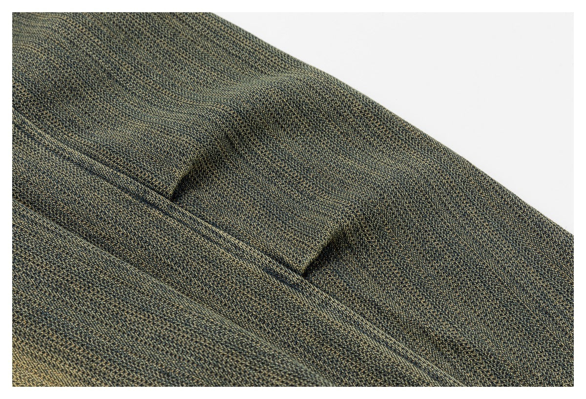 Close-up of textured olive-gray fabric with a folded seam and stitched edge.