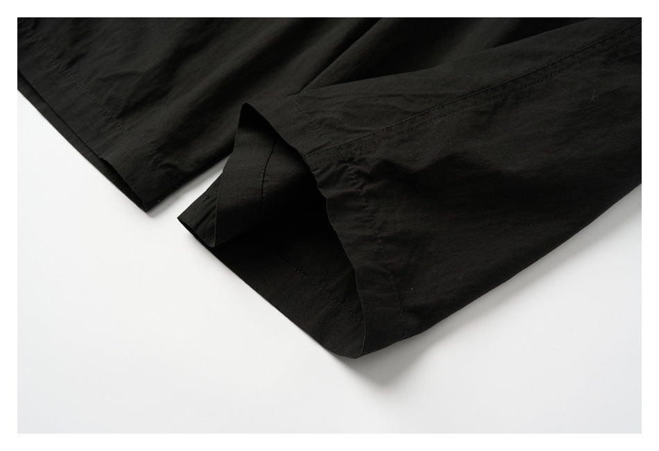 Close-up of the wide leg opening and hem of black pants.