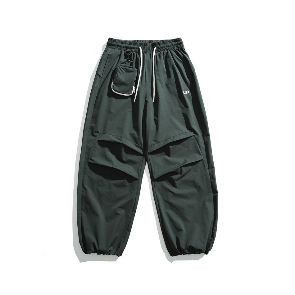 Army green wide-leg pants with white drawstring, clipped pouch, pleated knee panels and gathered cuffs, flat lay
