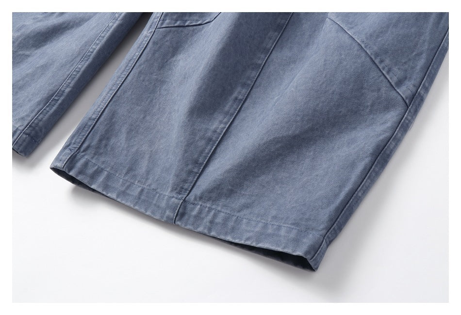 Close-up of blue-gray trouser leg panels and stitched hems.