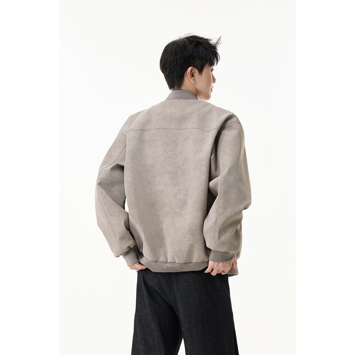Rear view of a model wearing a light taupe zip-front bomber jacket with ribbed collar, cuffs and hem.