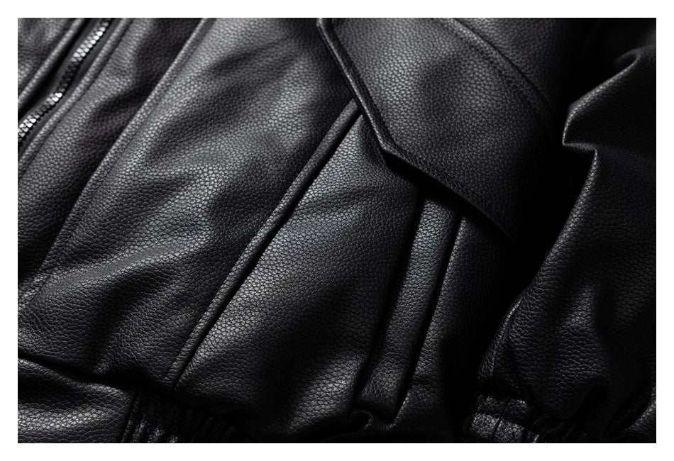 Close-up of a black jacket's flap pocket, pebbled panels and part of the front zipper.