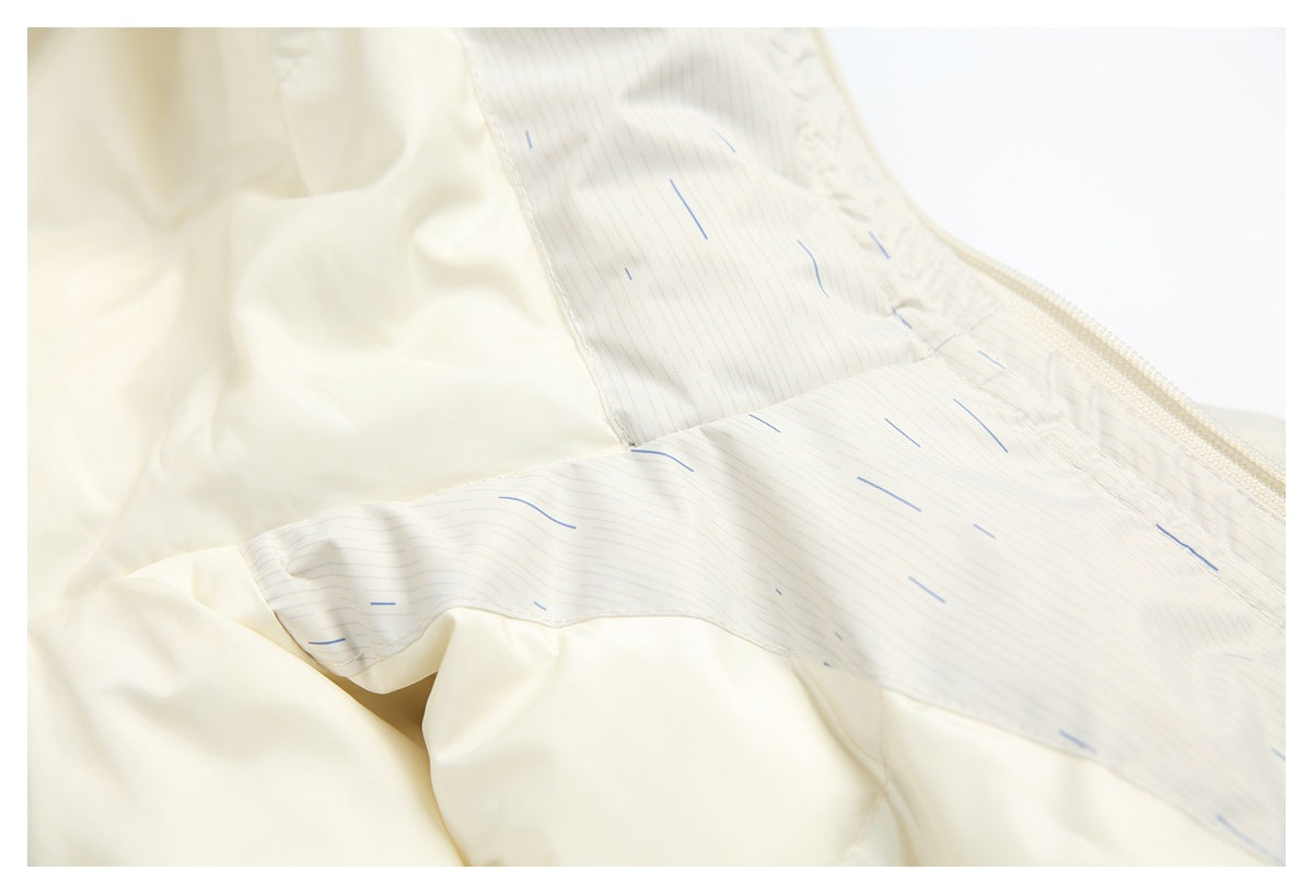 Close-up of a cream jacket interior with a pale striped facing and zipper seam.