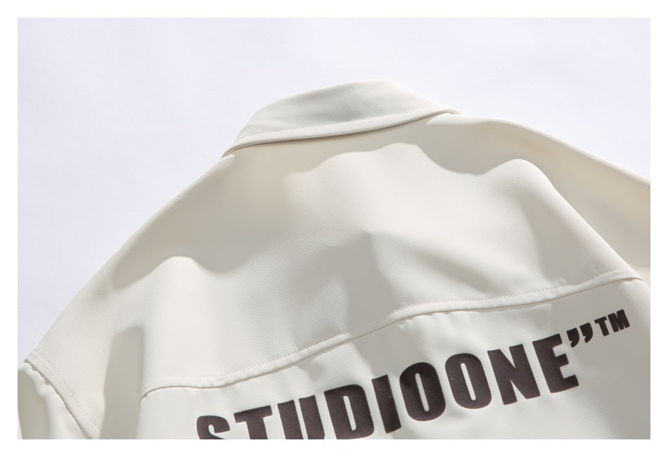 Close-up of the ivory shirt's back yoke and large dark STUDIOONE print.