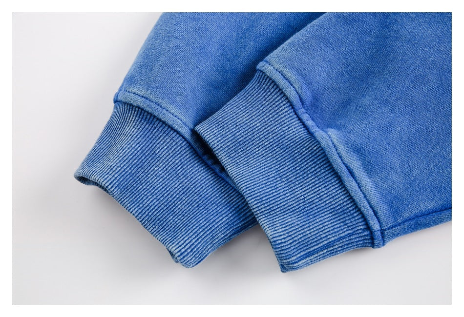 Close-up of blue sweatshirt sleeves with wide ribbed cuffs and visible stitching.