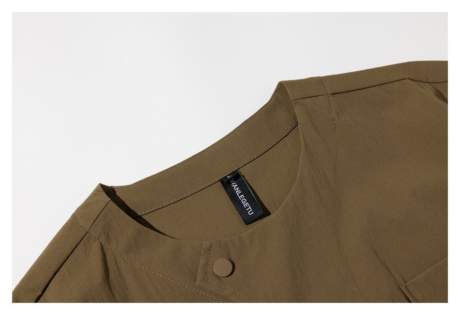 Close-up of an olive-brown garment’s round neckline, shoulder seam and button, with a black inner label.