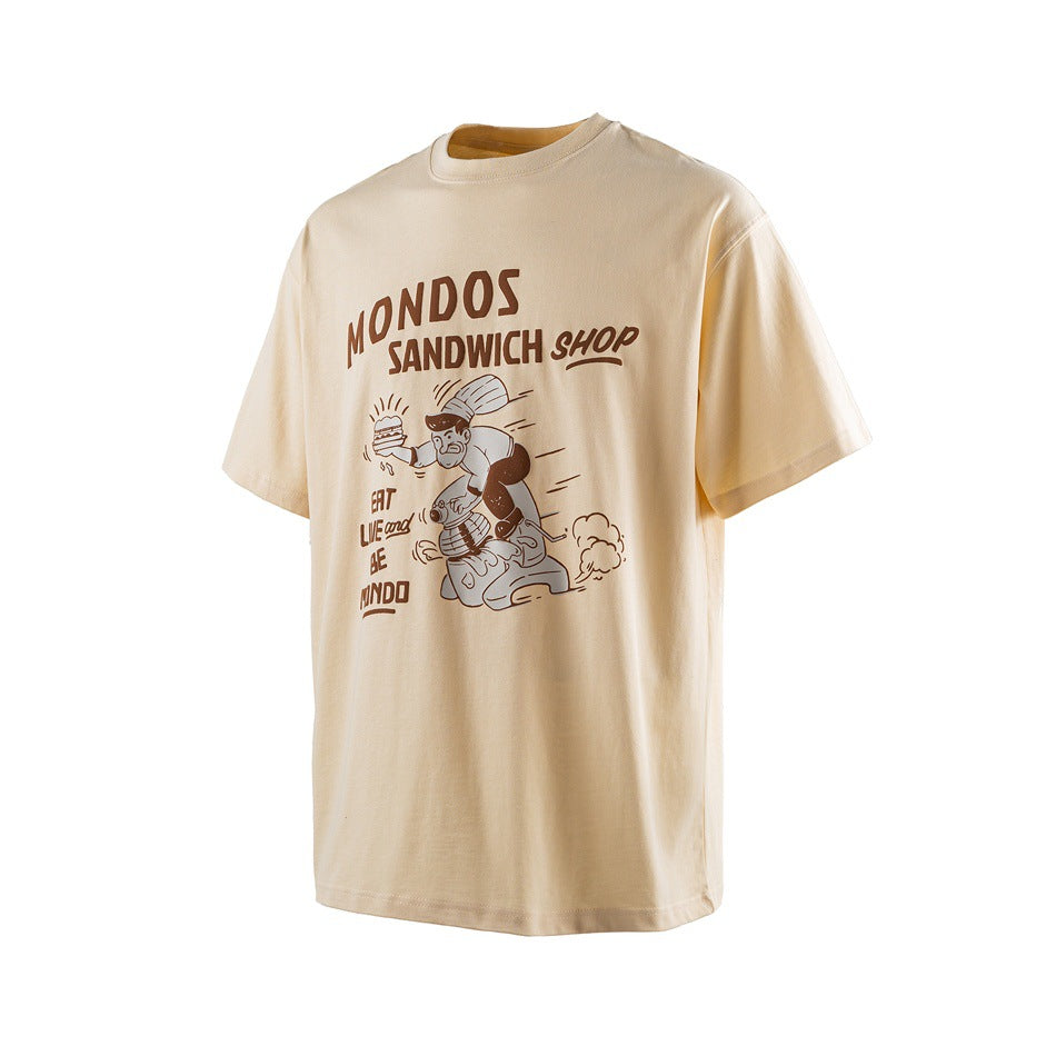 Light apricot short-sleeve T-shirt with brown MONDOS SANDWICH SHOP chef-on-scooter print, angled front view