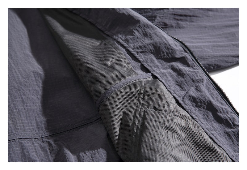 Close-up of the charcoal jacket interior, showing mesh panels and a front zipper.