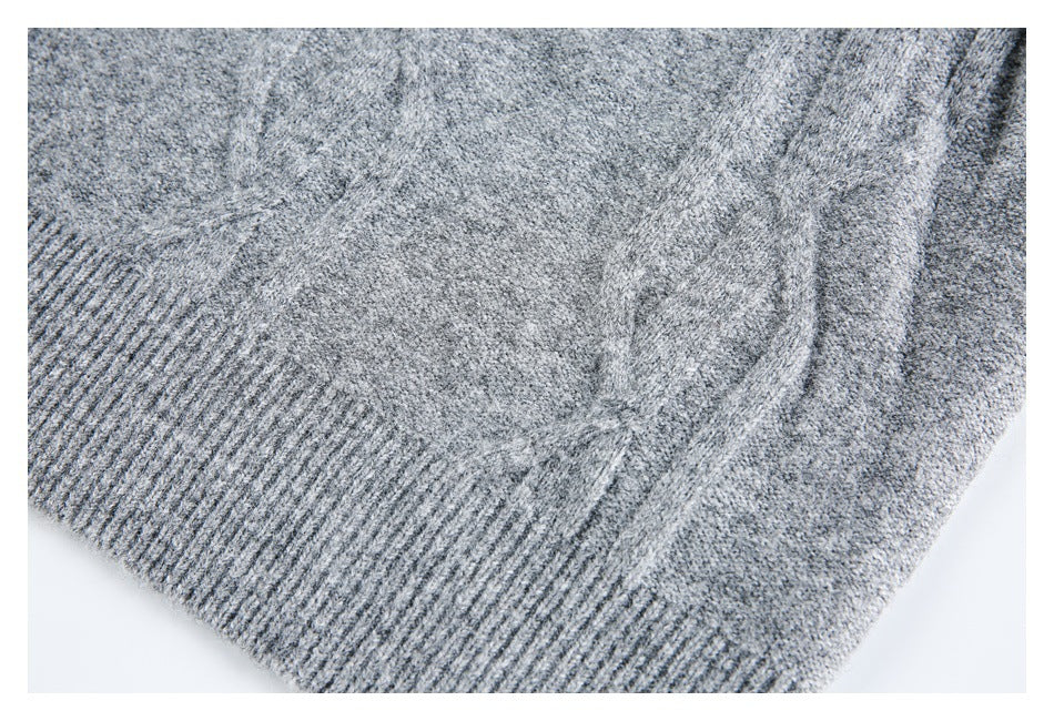 Close-up of gray knit fabric with a wide ribbed edge and adjoining seam.