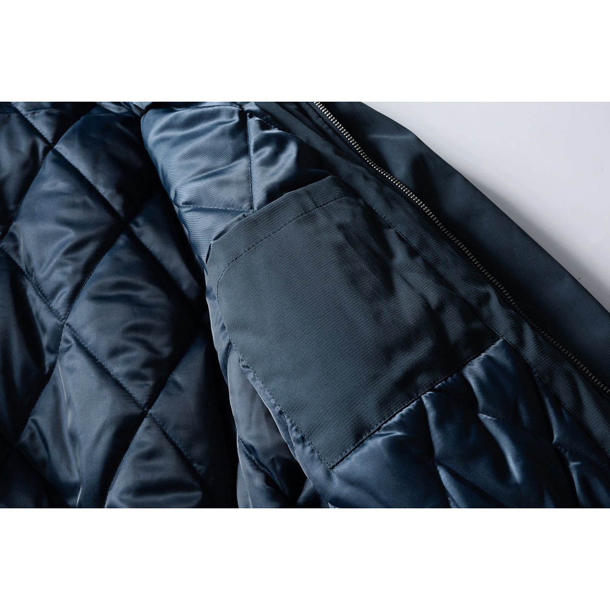 Close-up of the jacket’s dark quilted lining, inner pocket and open front zipper.
