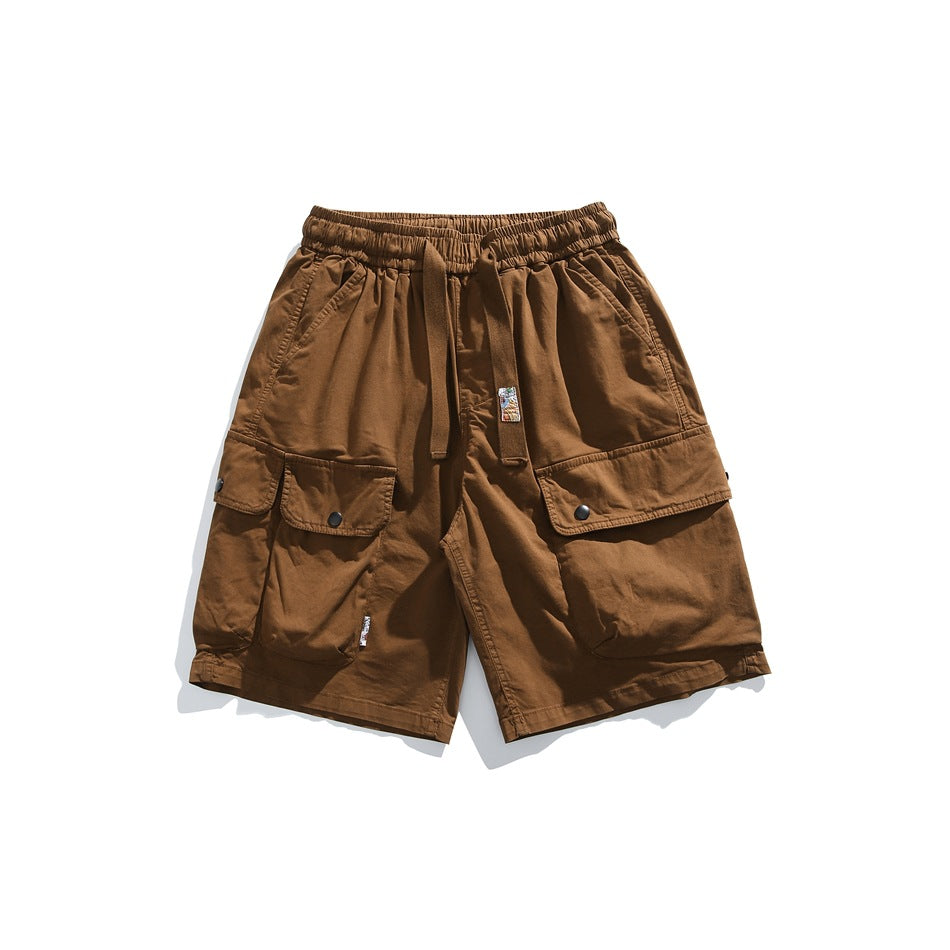 Light brown cargo shorts flat lay with drawstring waist and large snap flap cargo pockets