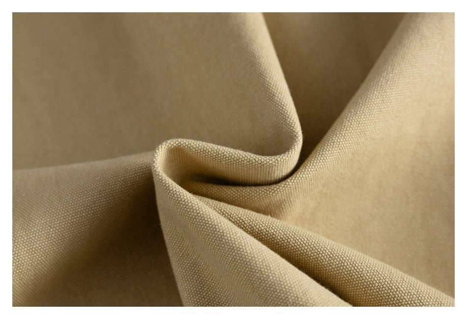 Macro view of the tan jacket's textured woven fabric gathered into folds.