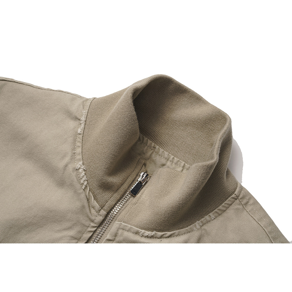 Close-up of a taupe jacket’s ribbed stand collar and front zipper.