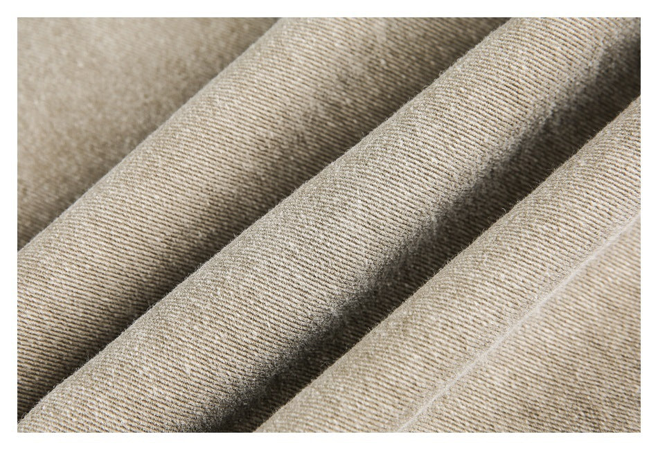Macro view of the beige garment's textured weave and folded fabric.