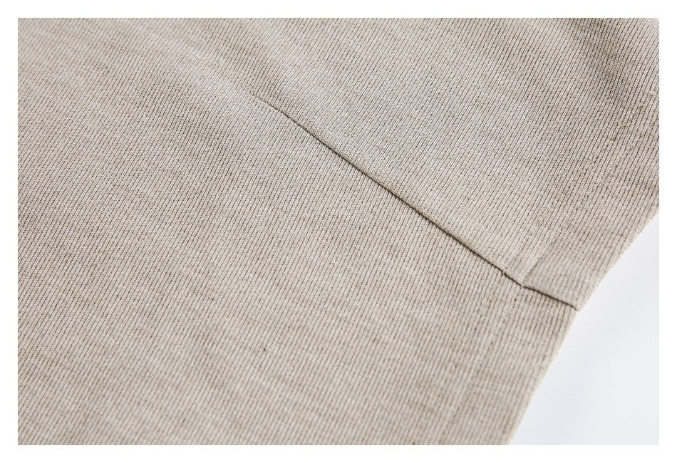 Close-up of a beige rib-knit garment panel with a diagonal seam.