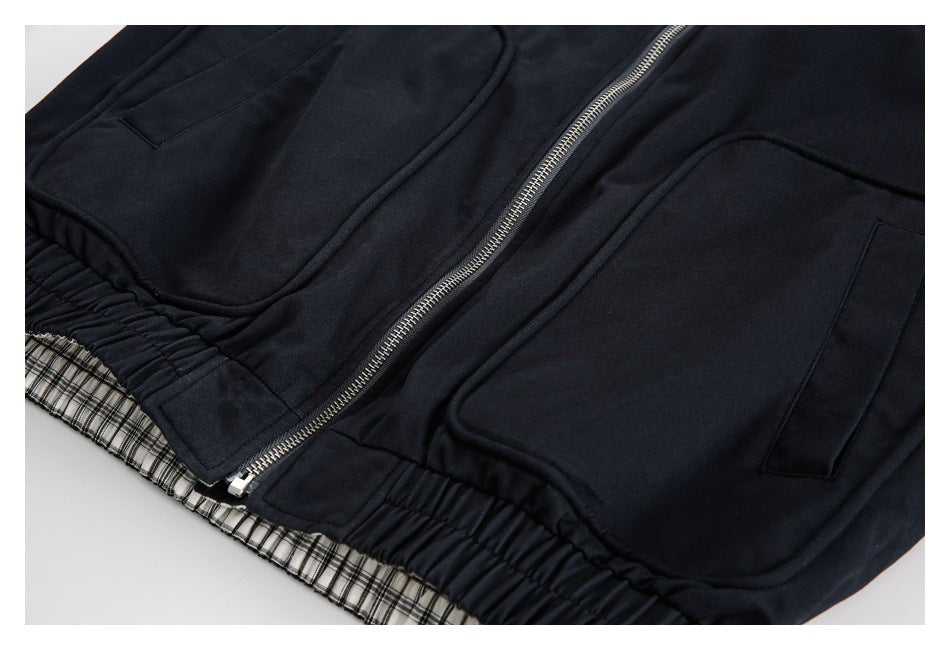 Close-up of the jacket's two front patch pockets, silver zipper, gathered hem, and plaid lining.