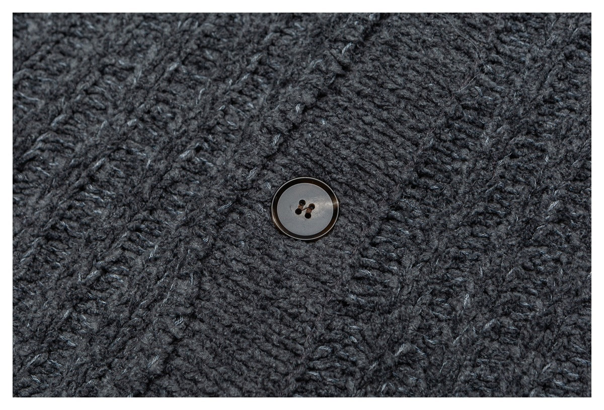 Close-up of a dark charcoal knit garment with a single round four-hole button.