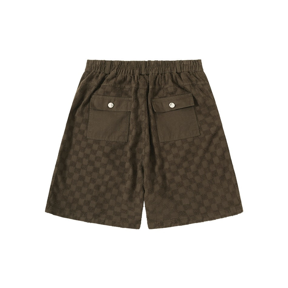 Back view of brown checkerboard jacquard shorts with elastic waistband and two button-flap pockets