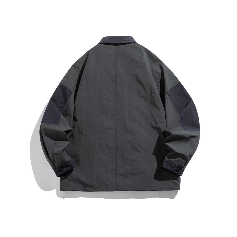 Back view of a charcoal-gray jacket with contrasting dark sleeve panels and button cuffs.