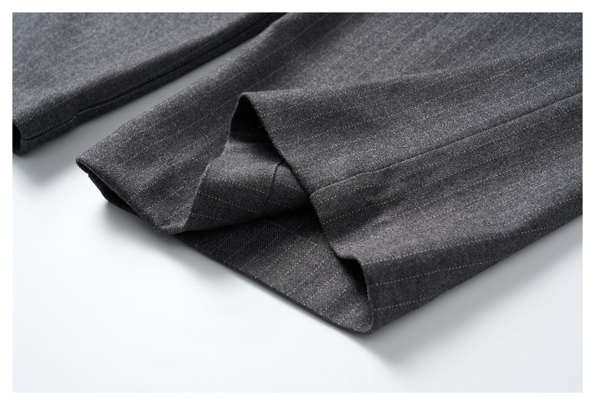 Close-up of a charcoal gray trouser hem folded to show its inside and stitching.