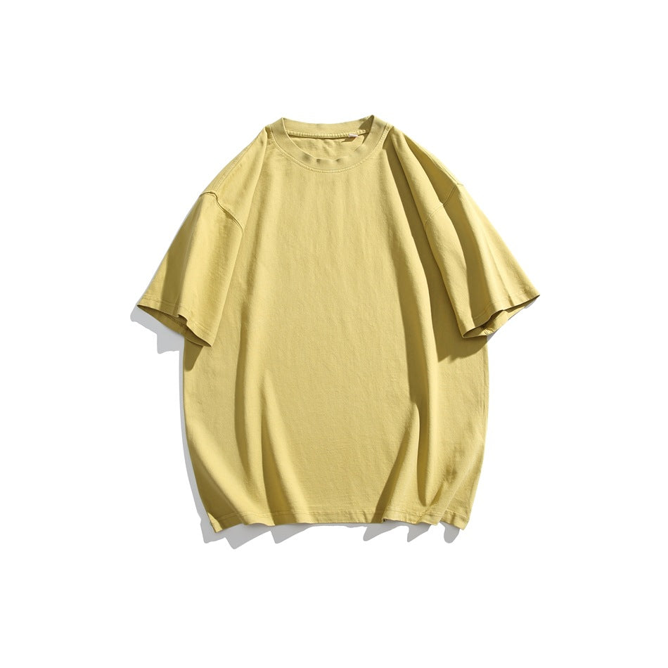 Muted yellow short-sleeve crew neck T-shirt with dropped shoulders, flat lay on a white background