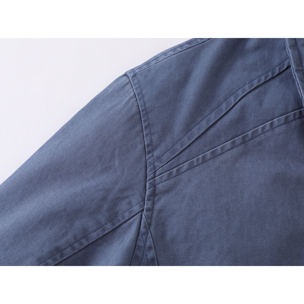 Close-up of the blue jacket's shoulder and sleeve seams.