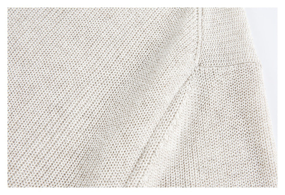 Close-up of cream open-knit fabric with a diagonal seam or fold.