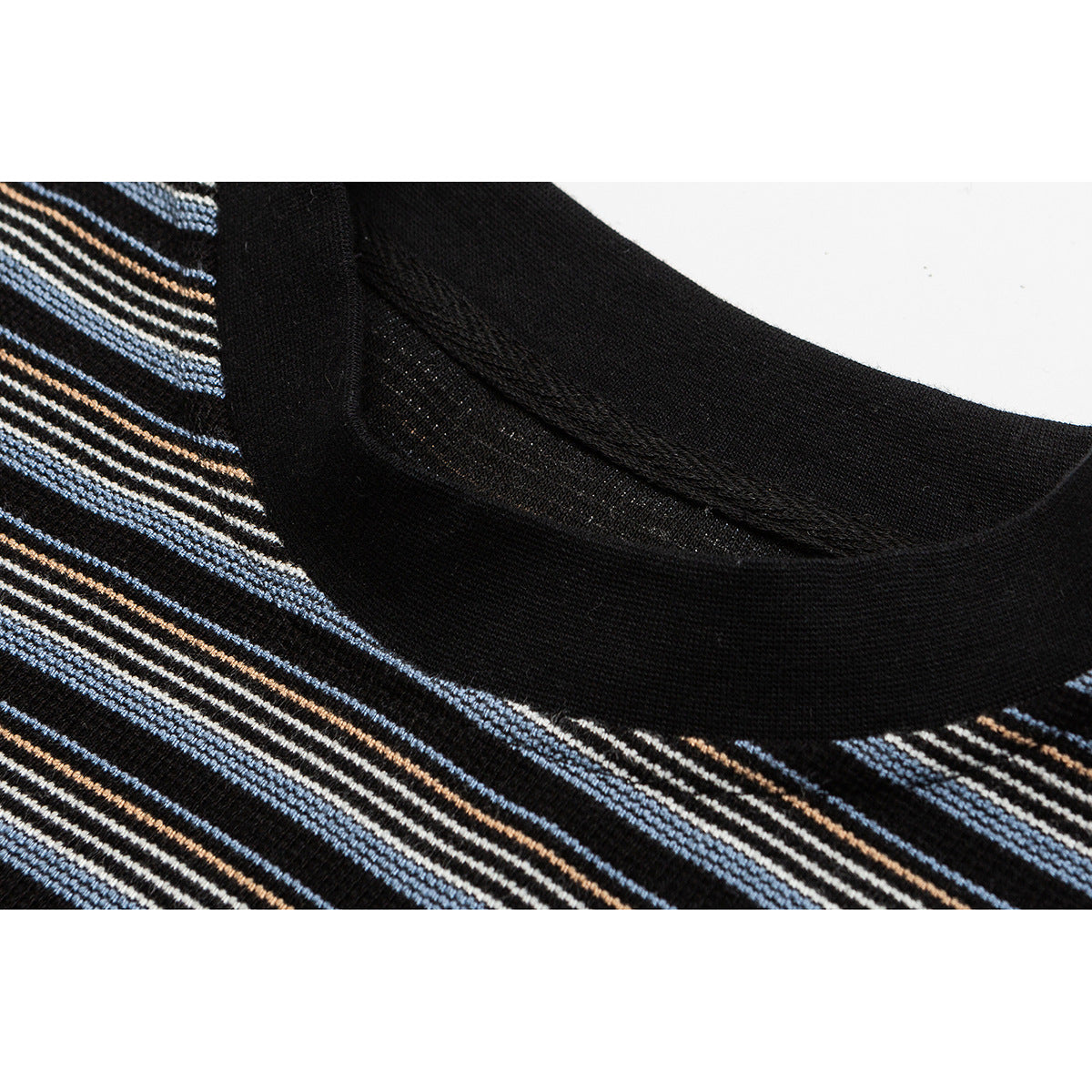 Close-up of a black ribbed crew neckline and blue, cream, and tan striped knit fabric.