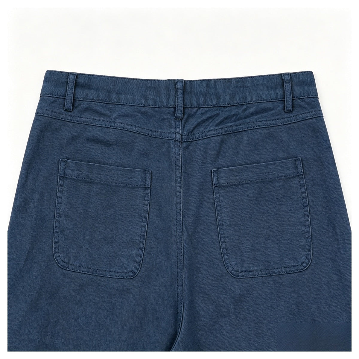 Close-up of the back of dark navy trousers, showing the waistband, belt loops, and two patch pockets.