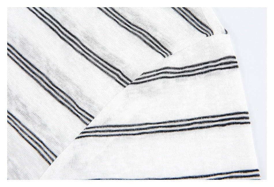 Close-up of white knit fabric with narrow black stripes meeting at a seam.