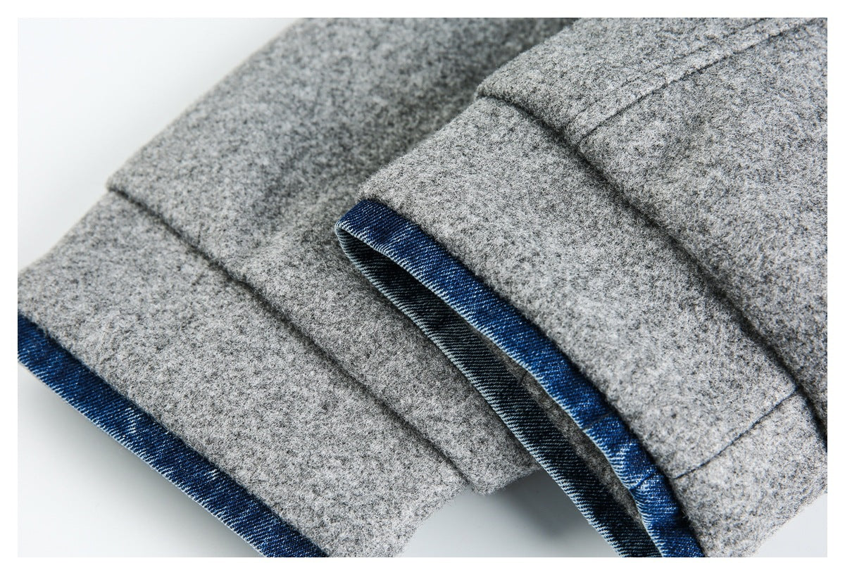 Close-up of gray jacket seams and a cuff edge finished with contrasting blue denim.