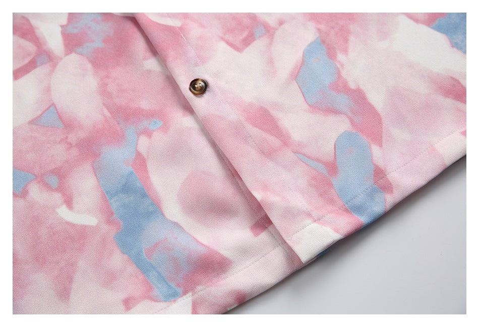 Close-up of the shirt's lower hem and front placket with a brown button and abstract print.