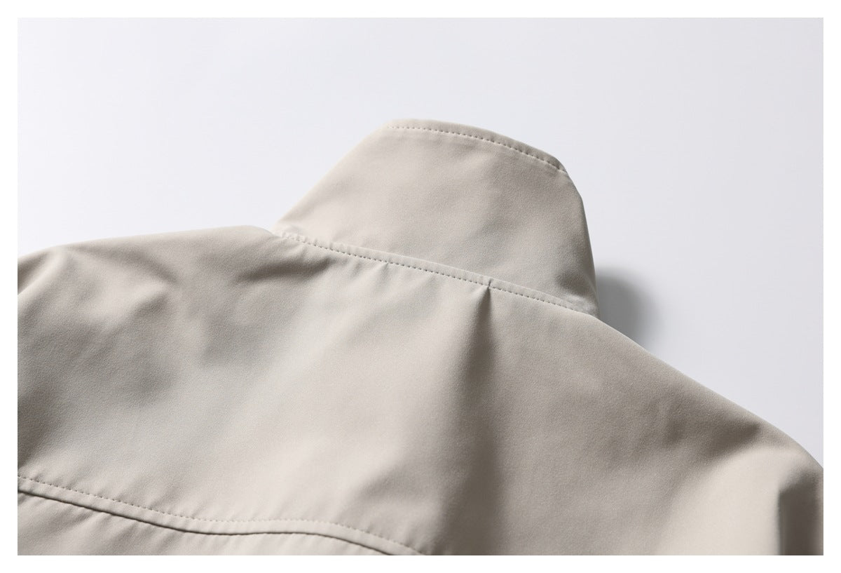 Close-up of the light taupe jacket’s raised collar and back yoke seam.