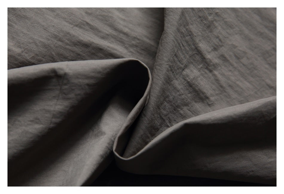Close-up of the charcoal-gray shorts fabric folded to show its surface and drape.