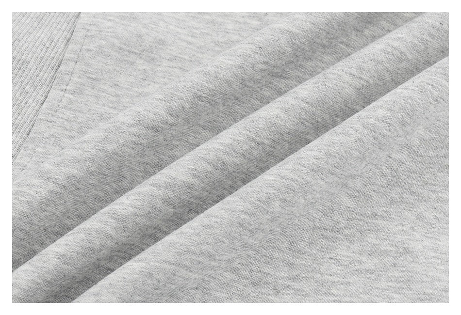 Close-up of soft-looking heather-gray garment fabric arranged in diagonal folds.