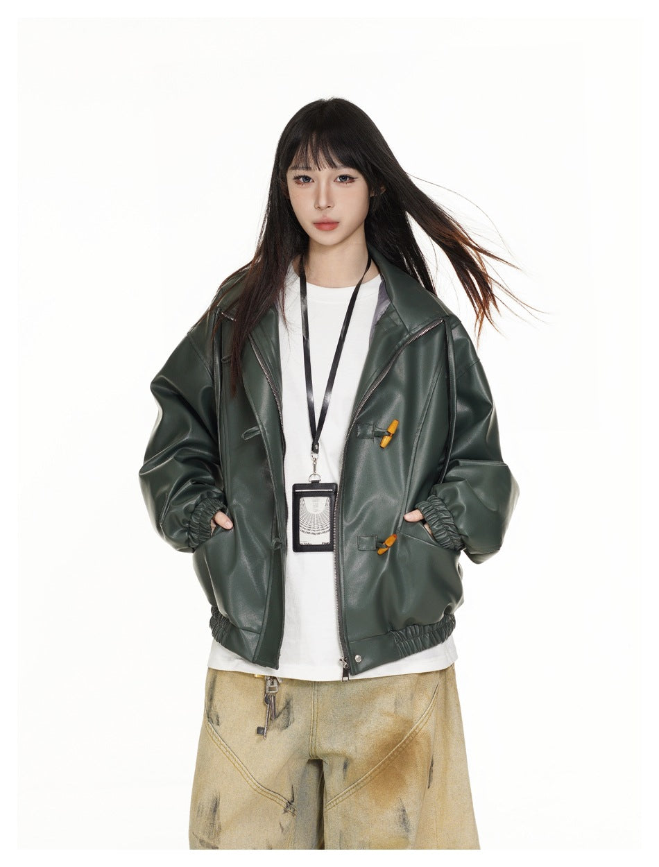 Closer view of a model wearing a dark green jacket with wide lapels, toggle details, and gathered cuffs.