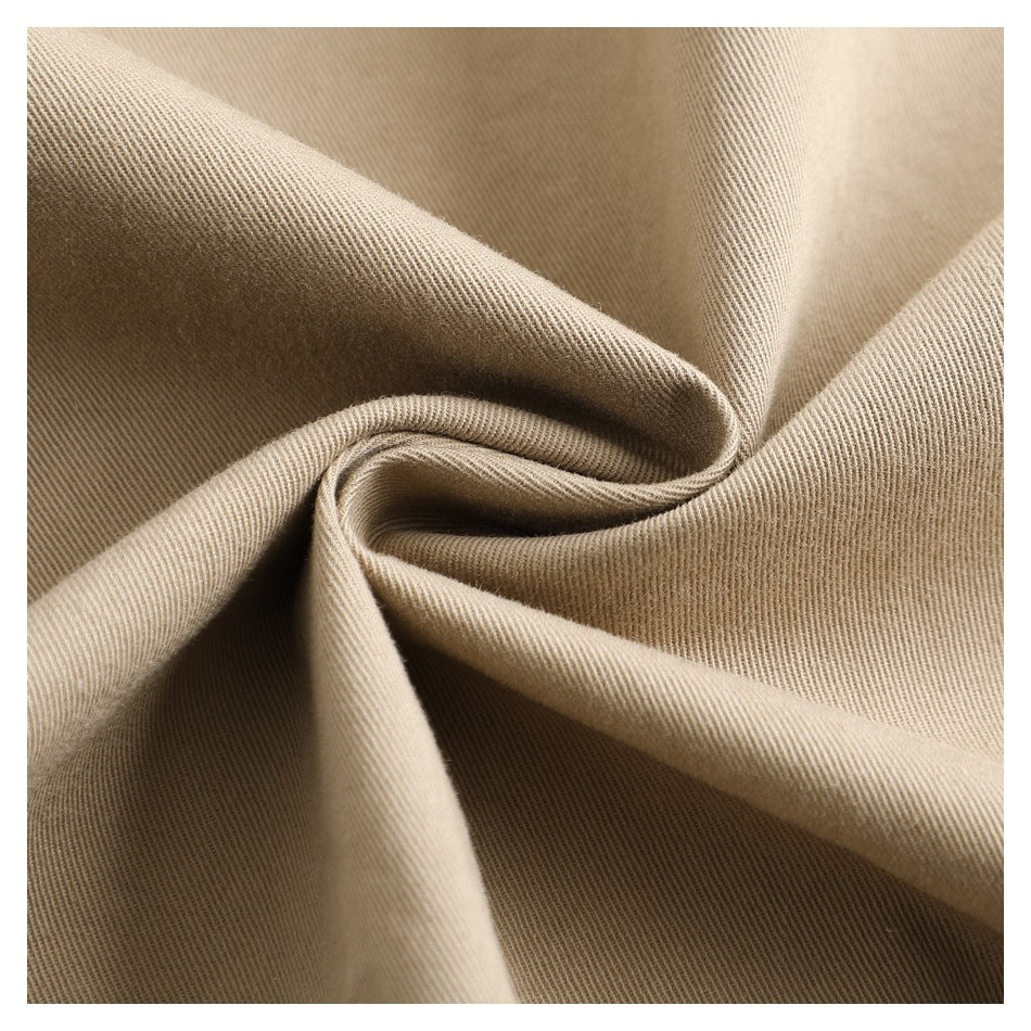 Close-up of beige fabric gathered into folds, showing its fine diagonal weave.
