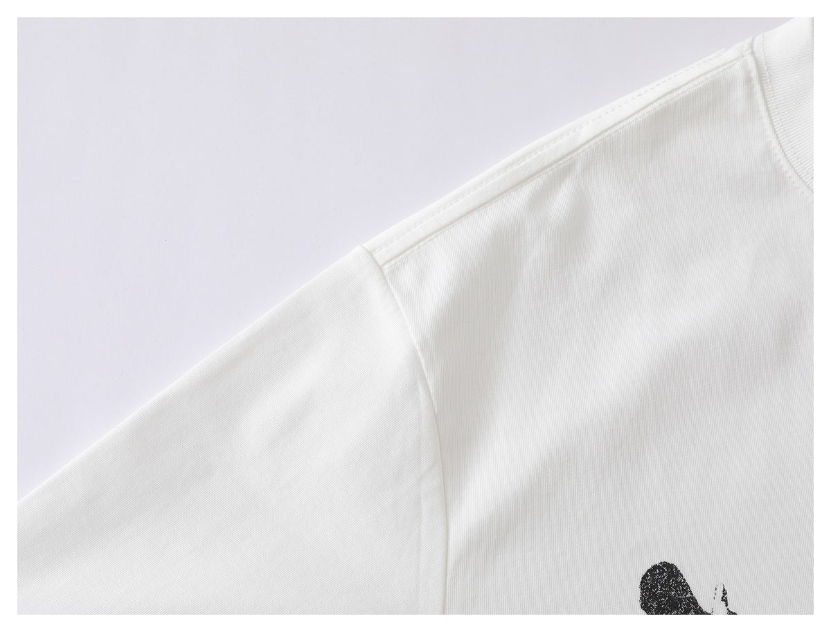 Close-up of a white T-shirt shoulder seam and sleeve, with part of a black graphic visible.