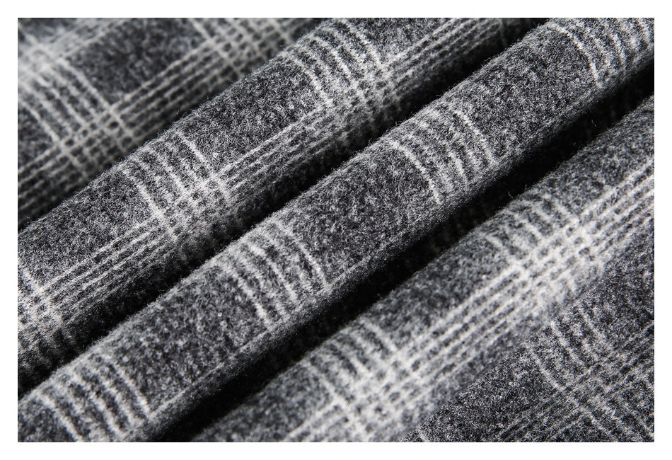 Macro view of folded gray and black plaid fabric, showing its fuzzy surface and white line pattern.