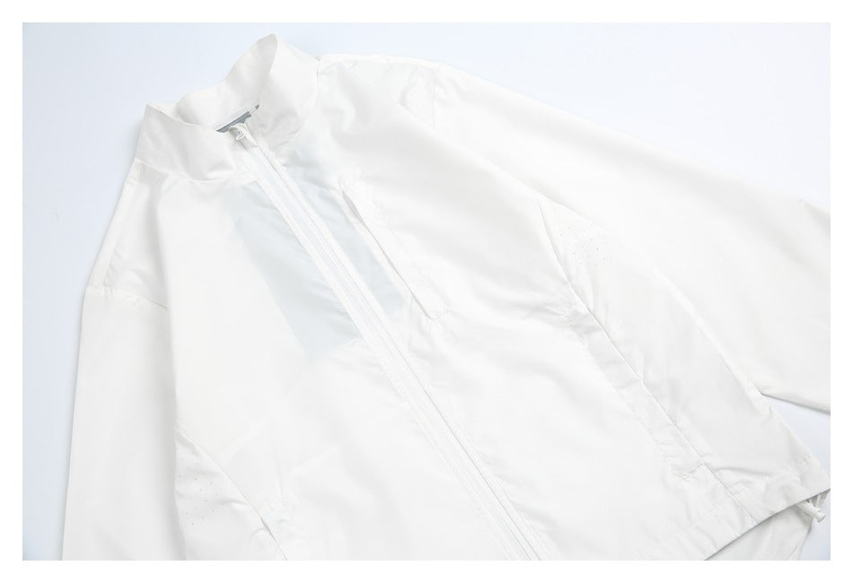 Close view of the white windbreaker’s front zipper, raised collar, seams, and perforated side panels.