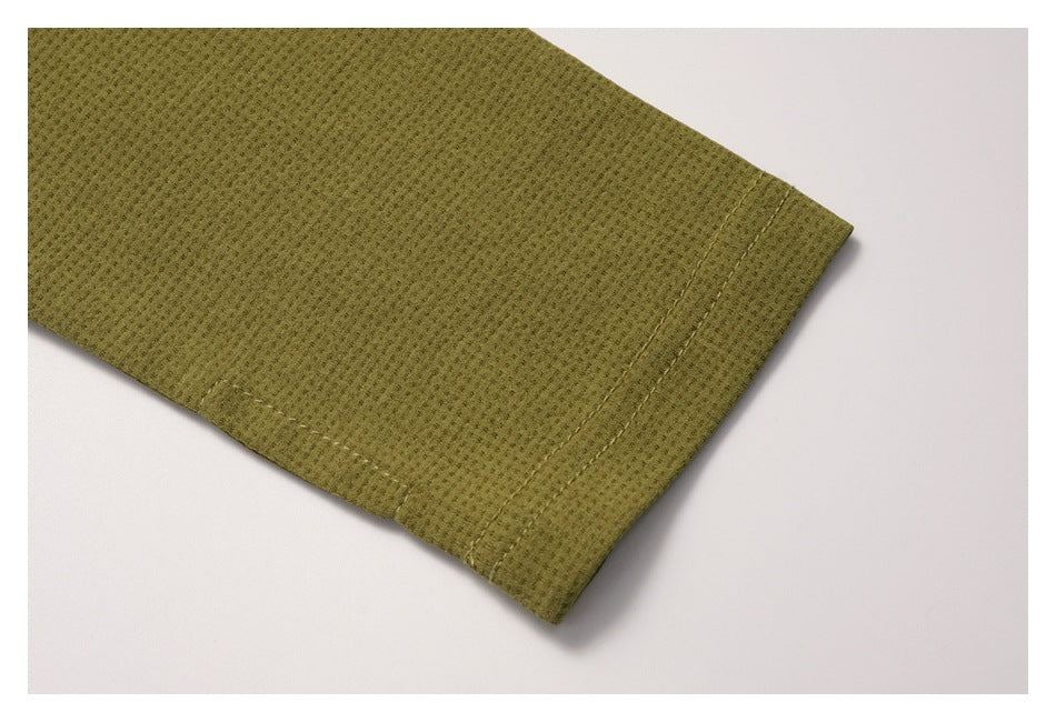 Close-up of an olive-green sleeve cuff with parallel rows of stitching.