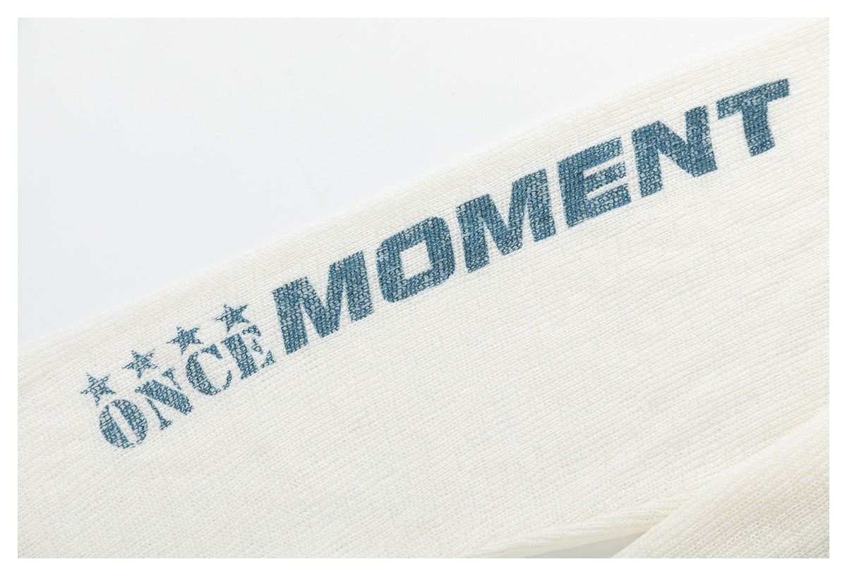 Close-up of blue lettering and star motifs printed on the ivory knit sleeve.
