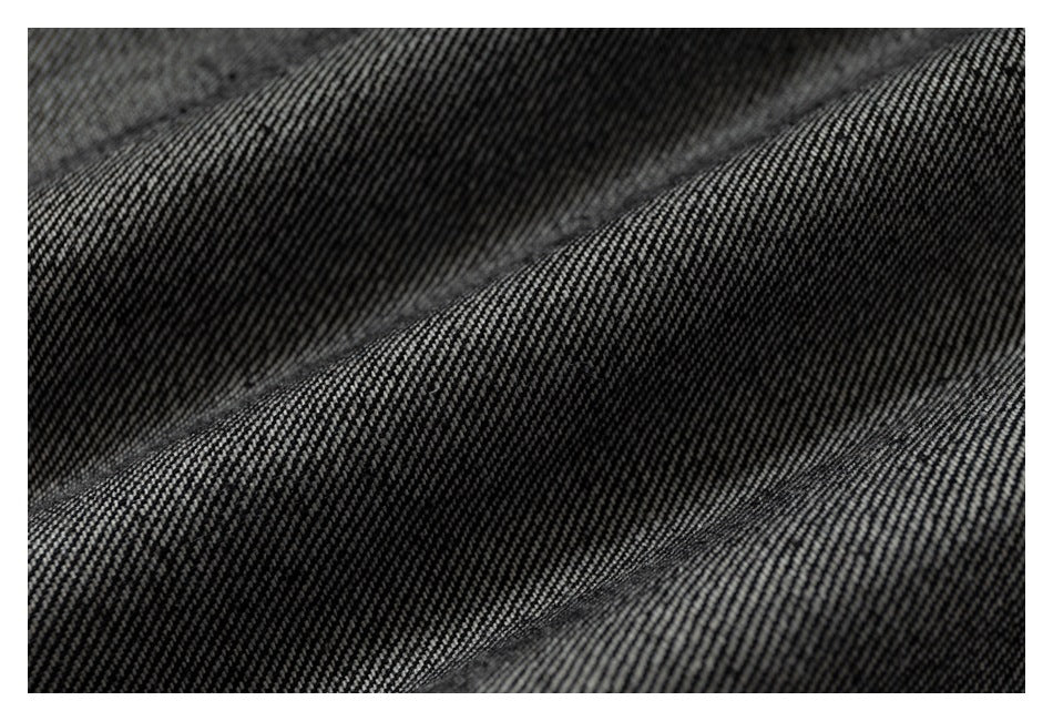Macro view of the trousers' dark gray woven fabric texture.