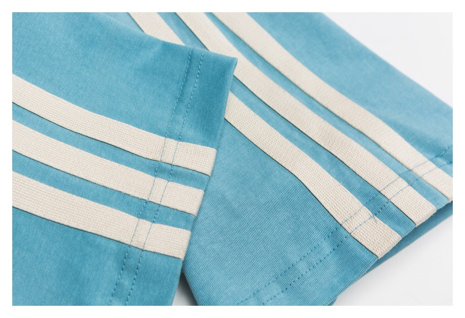 Close-up of a blue sleeve cuff and matching shirt panels with cream stripes and visible stitching.