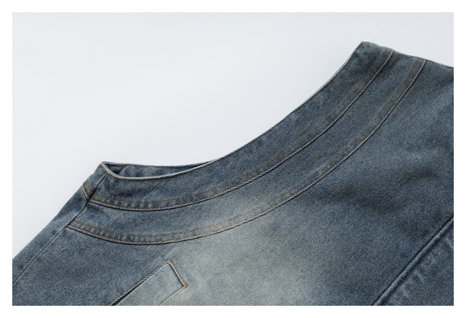 Close-up of a blue denim jacket neckline and curved shoulder seams.