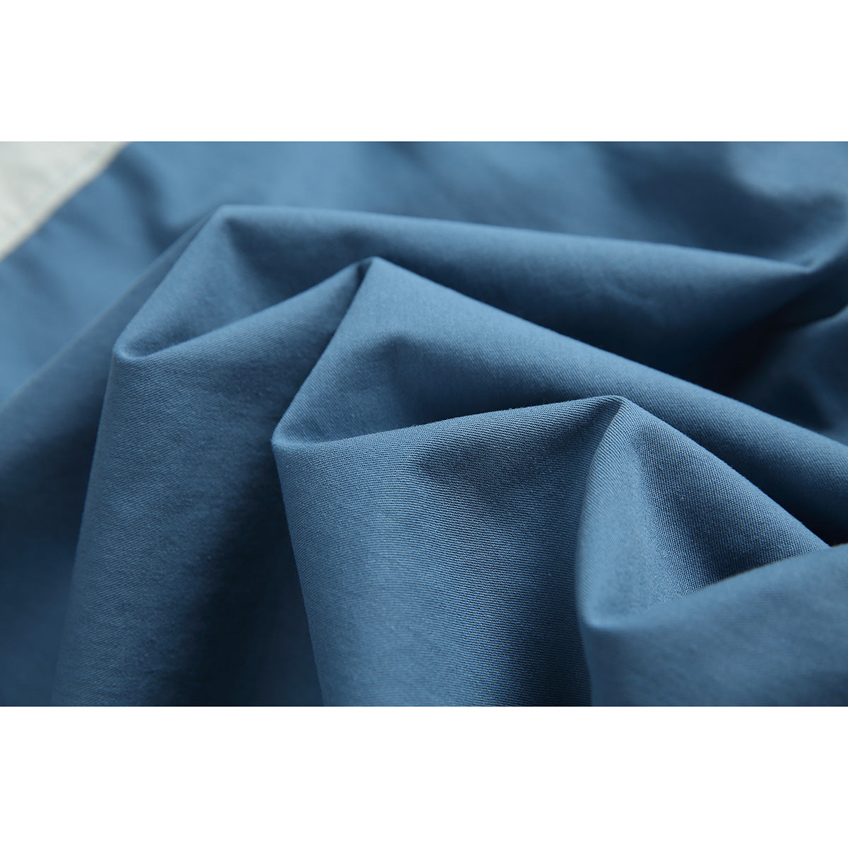 Close-up of blue shirt fabric arranged in soft folds.
