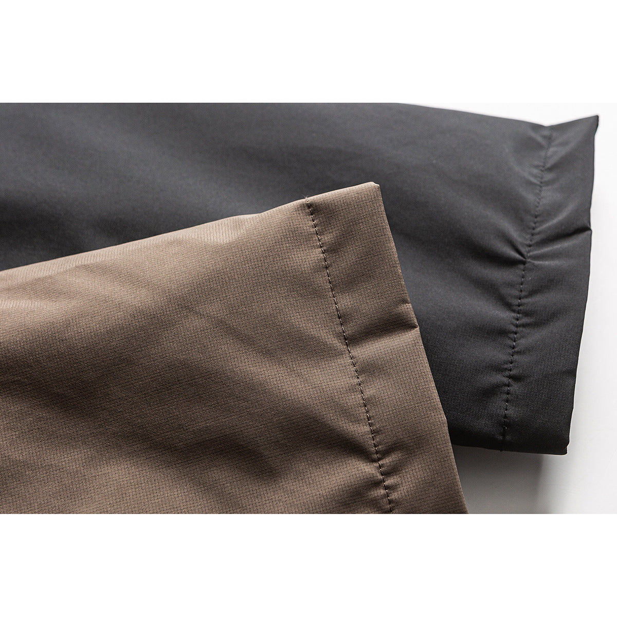 Close-up of brown and black jacket panels showing their contrasting colors and stitched seams.