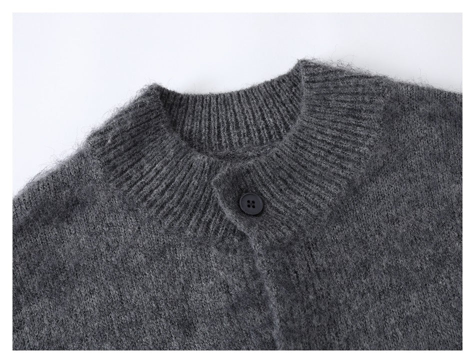 Close-up of a charcoal gray cardigan’s ribbed stand collar and single dark button.