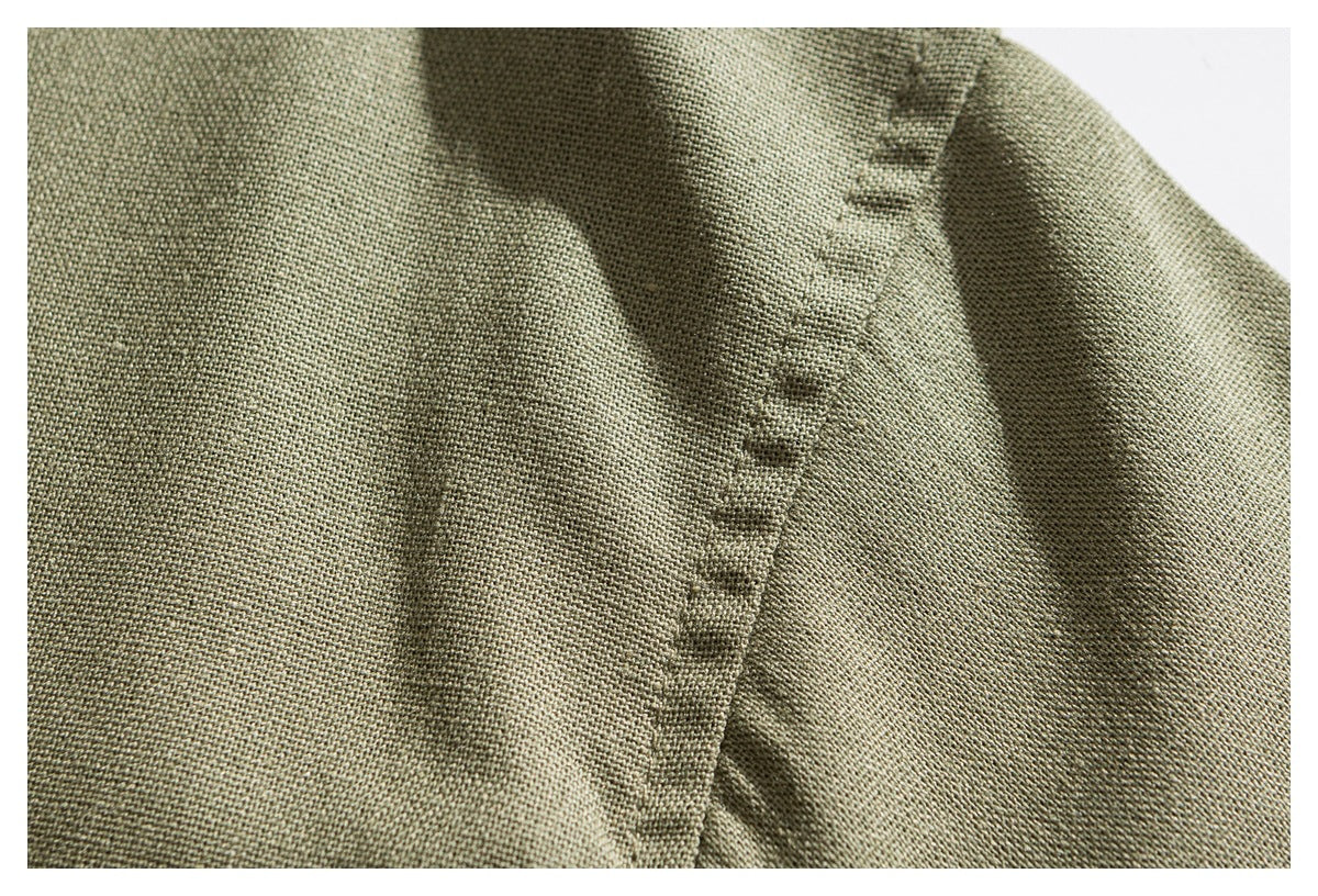 Close-up of olive green woven fabric with a narrow stitched seam between folds.